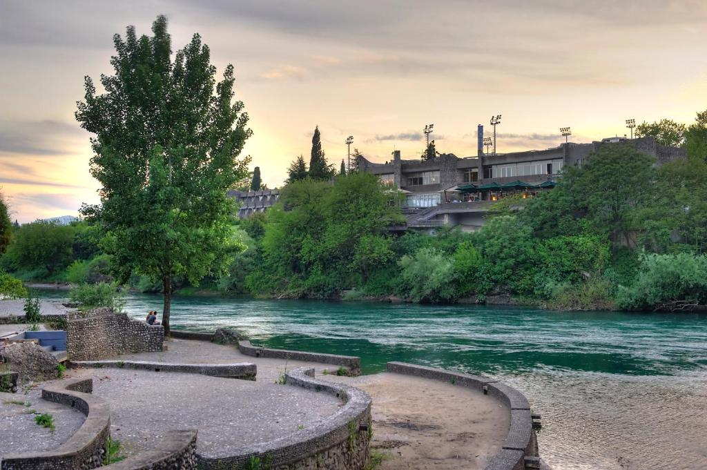 Hotel Podgorica seen across the green water of the Morača river