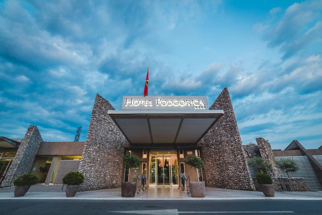 The stone-framed main entrance of Hotel Podgorica beneath a blue evening sky