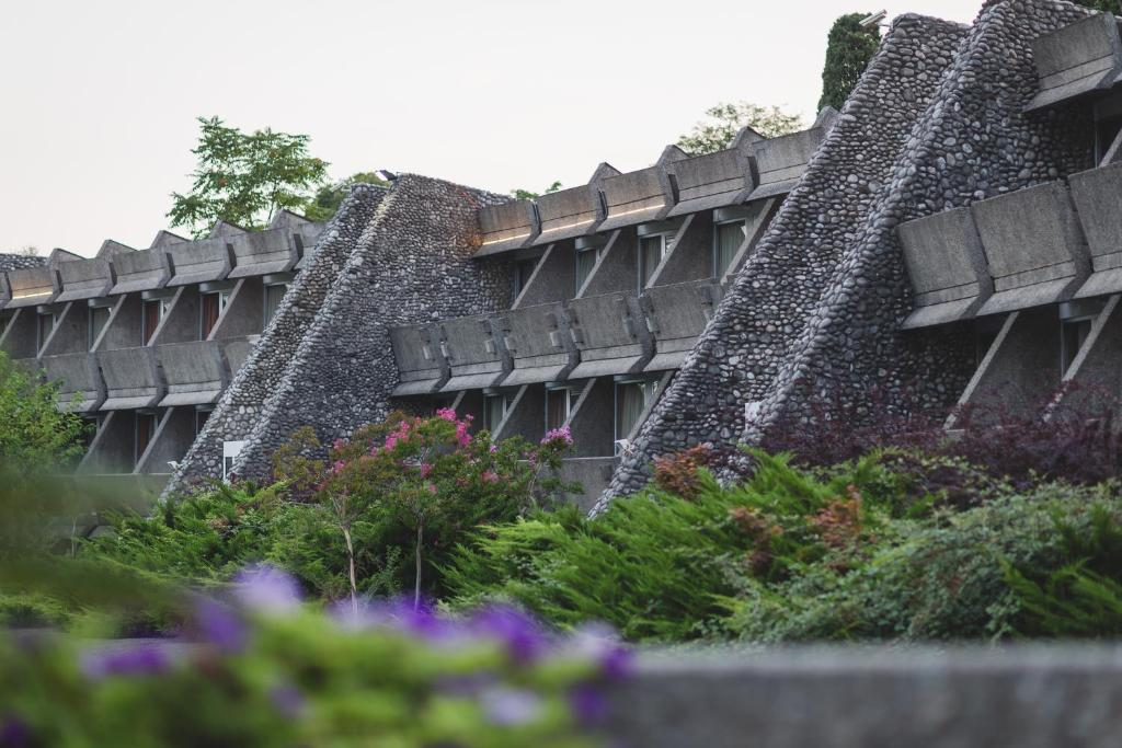 River-stone buttresses and concrete window bays at Hotel Podgorica